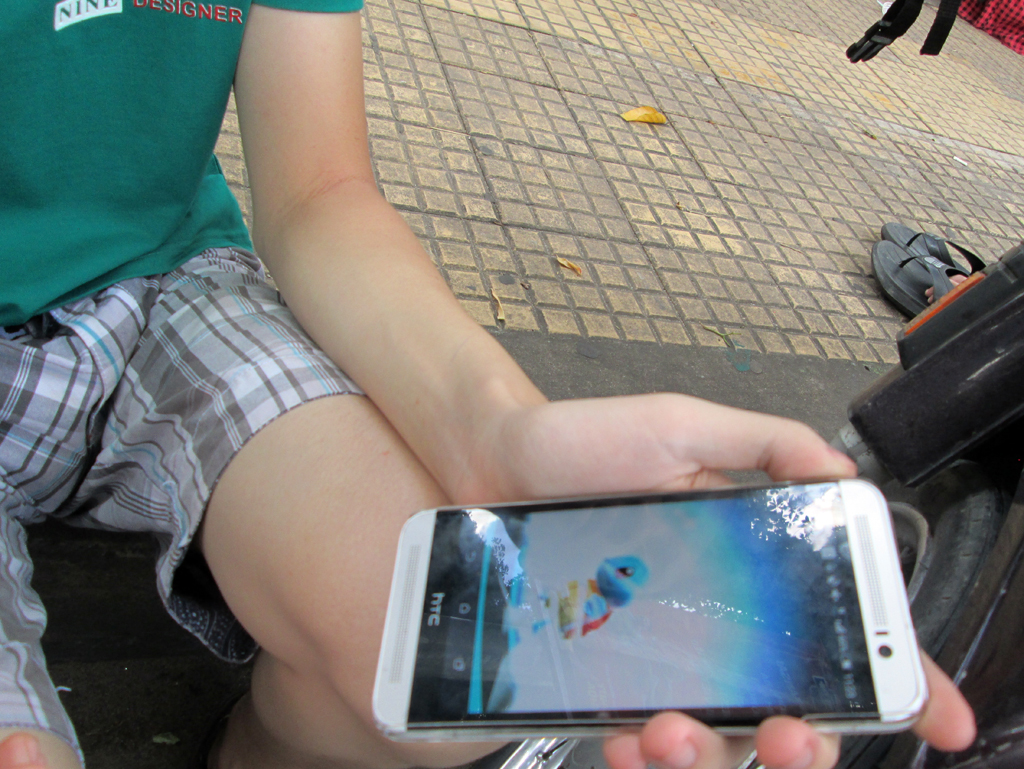 Một bạn trẻ vừa bắt được một con Pokémon. (Hình: Nguyễn Sài Gòn/Người Việt)