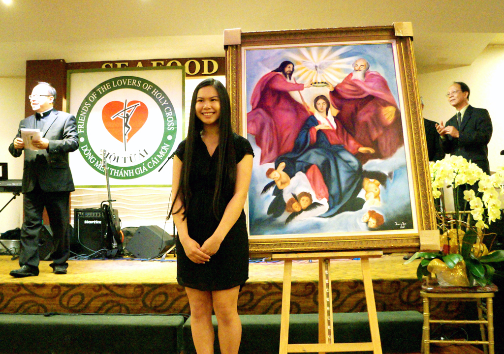 Em Jenny Ngô và bức tranh “Ðức Chúa Trời Thuận Ðức Mẹ Trên Trời.” (Hình: Lâm Hoài Thạch/Người Việt)