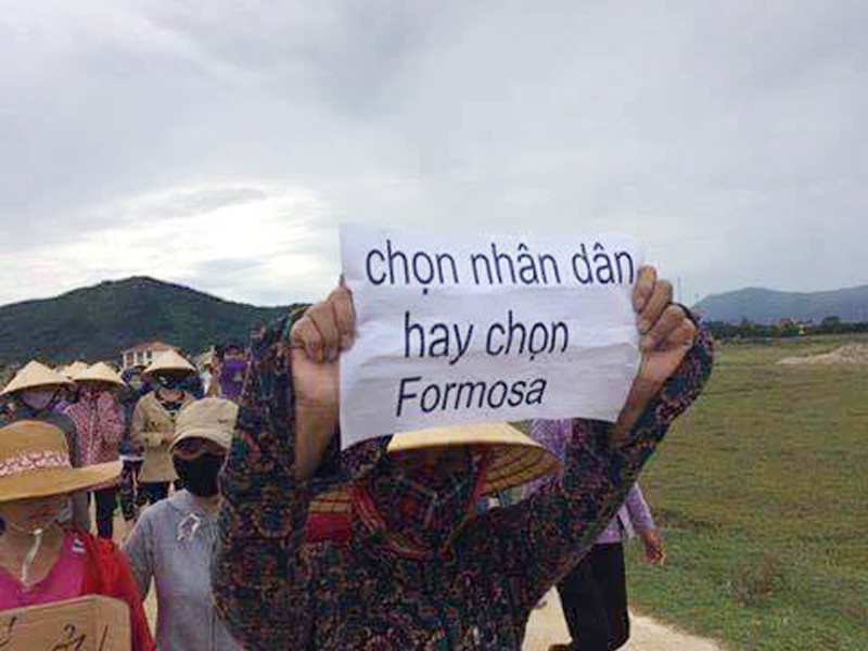 Một người dân đi biểu tình sáng 1 tháng 9, 2016 với tấm biểu ngữ “Chọn nhân dân hay chọn Formosa.” (Hình: FB Nguyễn Anh Tuấn)