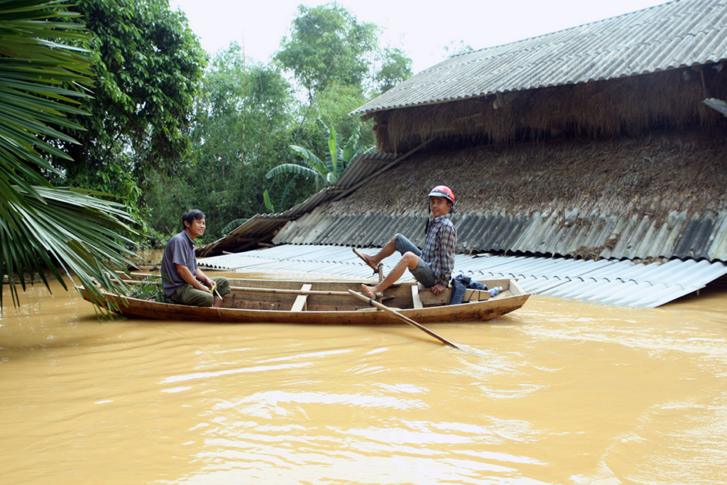 This picture taken on October 16, 2016 shows villagers in a boat rowing past flooded homes in a village in Huong Khe district in the central province of Ha Tinh. Severe flooding in central Vietnam has killed at least 25 people and destroyed thousands of homes, officials said on October 17, as the country braced for further destruction with a typhoon barrelling closer. / AFP / Vietnam News Agency / STR (Photo credit should read STR/AFP/Getty Images)