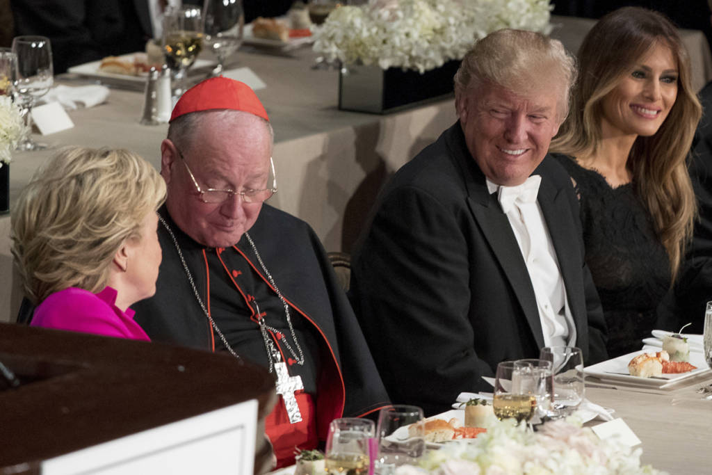From left, Democratic presidential candidate Hillary Clinton, Cardinal Timothy Dolan, Archbishop of New York, Republican presidential candidate Donald Trump, and his wife Melania Trump, sit together at the 71st annual Alfred E. Smith Memorial Foundation Dinner, a charity gala organized by the Archdiocese of New York, Thursday, Oct. 20, 2016, at the Waldorf Astoria hotel in New York. (AP Photo/Andrew Harnik)