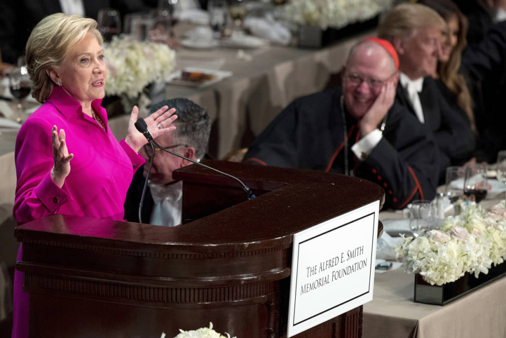 Democratic presidential candidate Hillary Clinton, accompanied by Cardinal Timothy Dolan, Archbishop of New York, second from right, and Republican presidential candidate Donald Trump, right, speaks at the 71st annual Alfred E. Smith Memorial Foundation Dinner, a charity gala organized by the Archdiocese of New York, Thursday, Oct. 20, 2016, at the Waldorf Astoria hotel in New York. (AP Photo/Andrew Harnik)