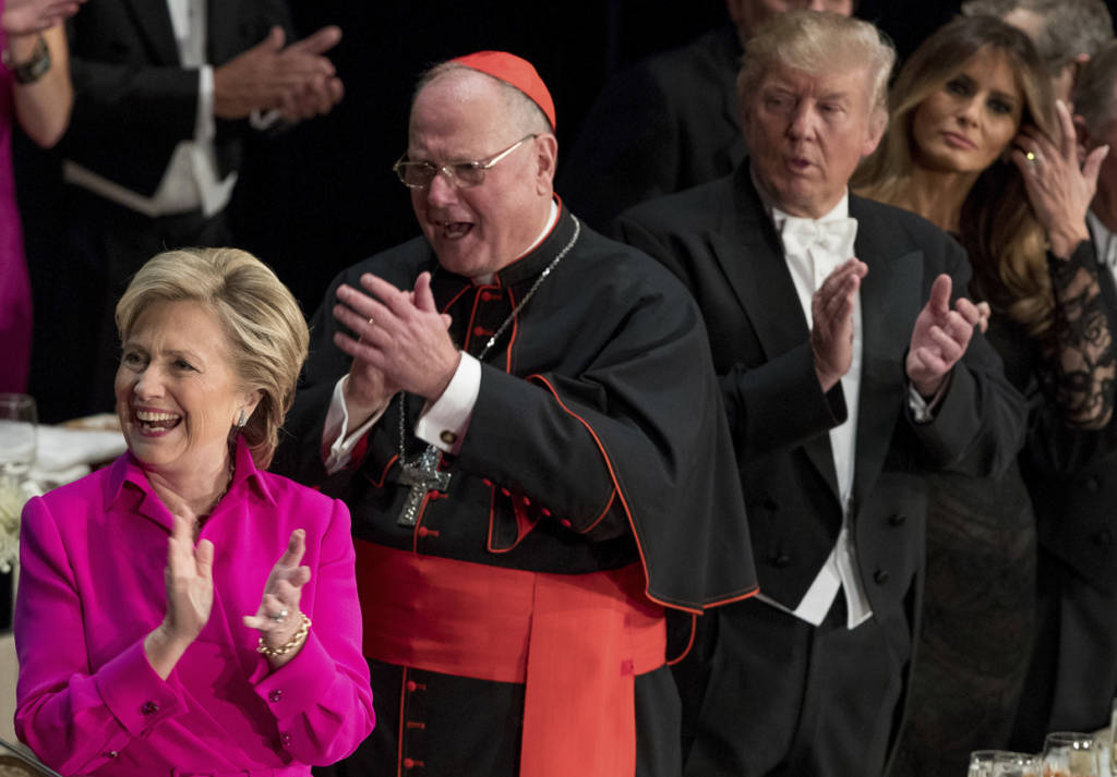 From left, Democratic presidential candidate Hillary Clinton, Cardinal Timothy Dolan, Archbishop of New York, Republican presidential candidate Donald Trump, and his wife Melania Trump, applaud after the National Anthem at the 71st annual Alfred E. Smith Memorial Foundation Dinner, a charity gala organized by the Archdiocese of New York, Thursday, Oct. 20, 2016, at the Waldorf Astoria hotel in New York. (AP Photo/Andrew Harnik)