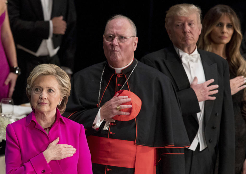 From left, Democratic presidential candidate Hillary Clinton, Cardinal Timothy Dolan, Archbishop of New York; Republican presidential candidate Donald Trump, and his wife Melania Trump, stand for the National Anthem at the 71st annual Alfred E. Smith Memorial Foundation Dinner, a charity gala organized by the Archdiocese of New York, Thursday, Oct. 20, 2016, at the Waldorf Astoria hotel in New York. (AP Photo/Andrew Harnik)