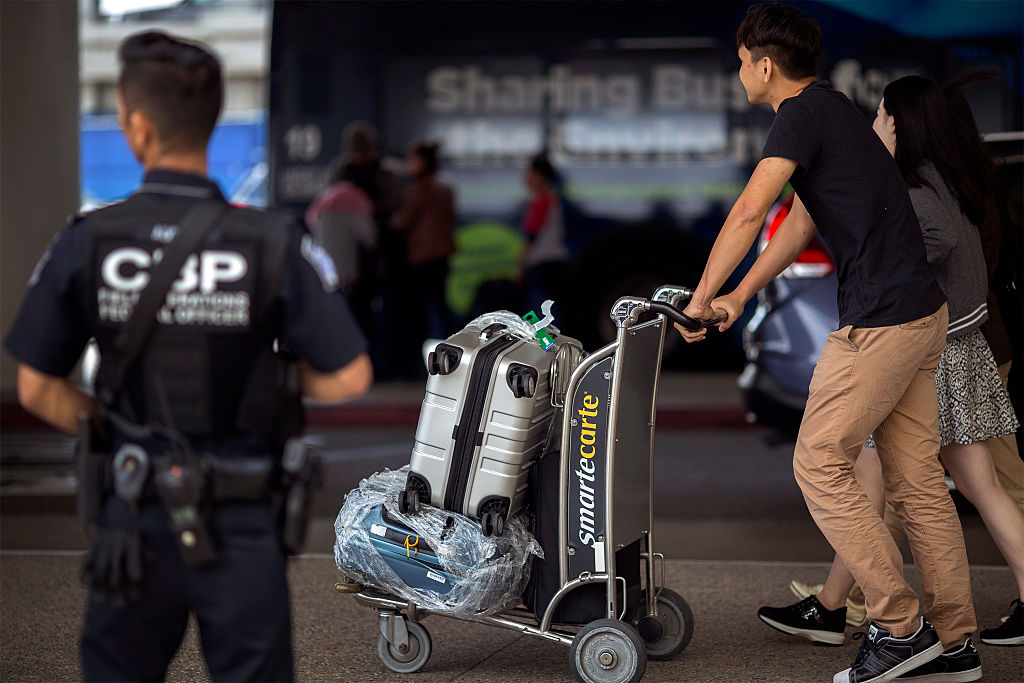 LOS ANGELES, CA - JULY 02: A U.S. Customs and Border Protection officer watches over travelers at Los Angeles International Airport on July 2, 2016 in Los Angeles, California. Security is stepped up for the busy Fourth of July travel weekend following deadly attacks on an airport in Turkey that claimed 44 lives, and in Bangladesh where 20 hostages were killed. A pro-ISIS twitter account threatened attacks at airports in Los Angeles, London Heathrow and New York JFK airports but officials are doubting its credibility. (Photo by David McNew/Getty Images)
