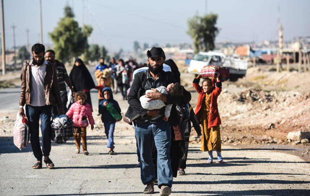 Iraqi families, who fled the violence due to the ongoing operation by Iraqi forces against jihadists of the Islamic State group to retake the city of Mosul, walk on November 3, 2016 as they leave Gogjali, which lies on the eastern edge of Mosul, before heading to camps housing displaced people. Some civilians were leaving Gogjali and others the eastern Mosul neighbourhood of Samah, in what may be a rare breach for civilians trapped inside the city. More than 21,000 people have fled to government-held areas since October 17, while thousands more may have been seized by IS for use as human shields, according to the United Nations. / AFP / BULENT KILIC (Photo credit should read BULENT KILIC/AFP/Getty Images)