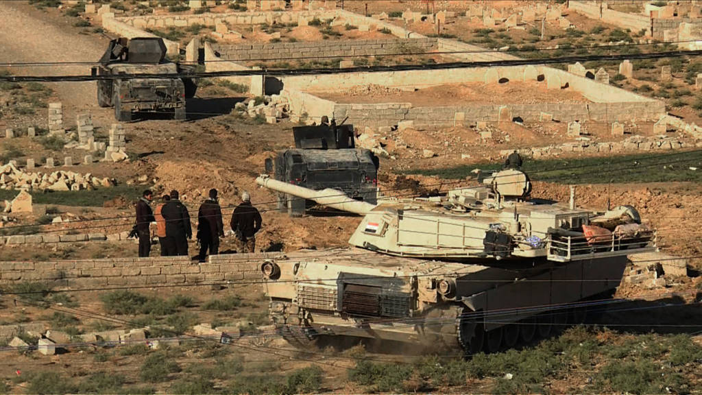 An image grab taken from AFPTV shows an Iraqi forces M1 Abrams tank and armoured vehicles holding a position on the edge of the Al-Karamah district of eastern Mosul on November 4, 2016, during a military operation to retake the main hub city from the Islamic State (IS) group jihadists. Jihadist fighters unleashed a deluge of bombs and gunfire on Iraqi forces punching into the streets of Mosul for the first time, forcing some units into a partial pullback. / AFP / AFPTV / Andrea BERNARDI (Photo credit should read ANDREA BERNARDI/AFP/Getty Images)