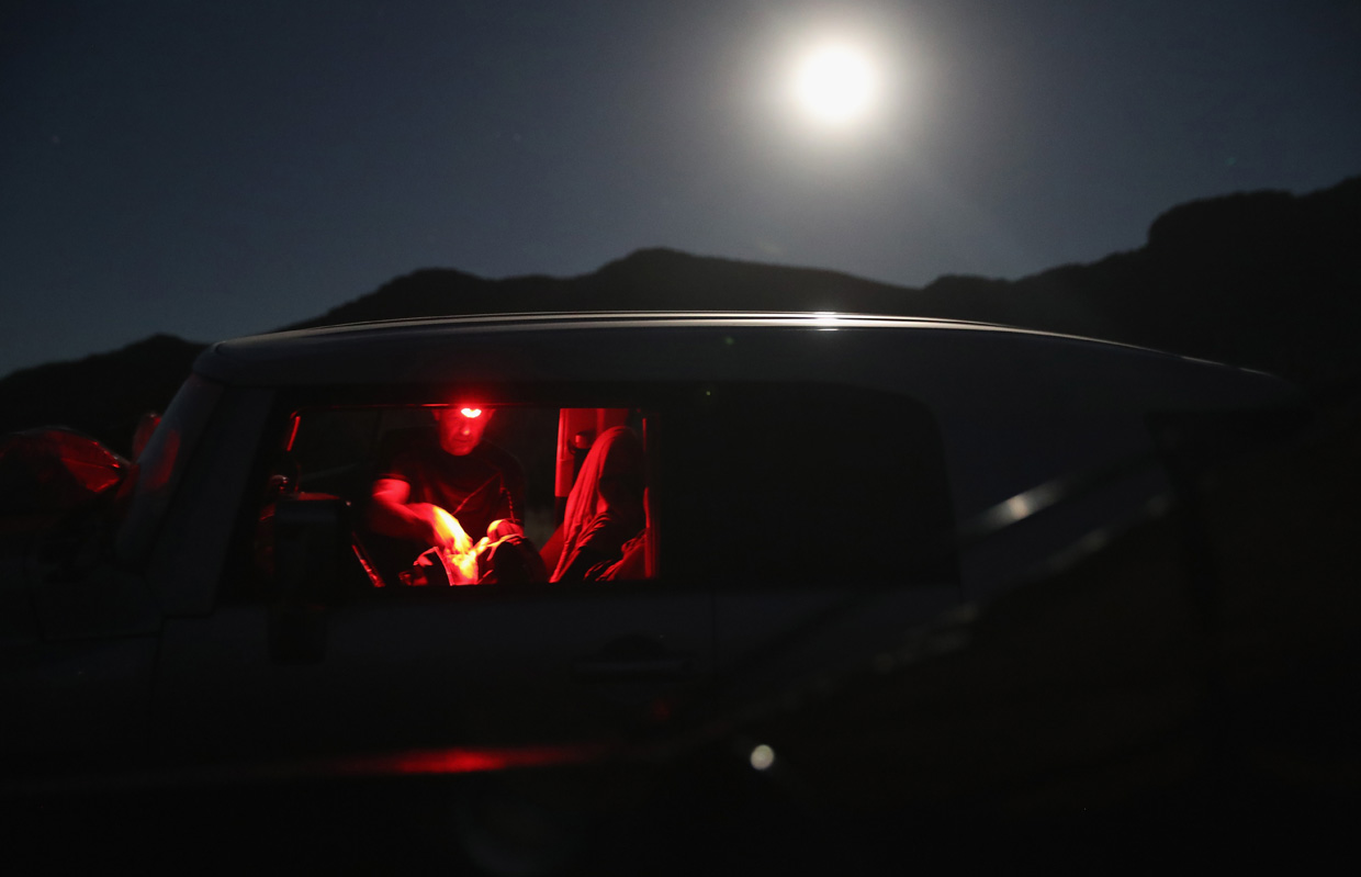 ARIVACA, AZ - NOVEMBER 14: A civilian paramilitary with Arizona Border Recon eats under a full moon while on an operation at the U.S.-Mexico border on November 14, 2016 near Arivaca, Arizona. The armed group, made up mostly of former U.S. military servicemen and women, stages intelligence and reconnaissance operations against drug and human smuggling operations in remote border areas. The group, which claims up to 200 volunteers, does not consider itself a militia, but rather a group of citizens supplementing U.S. Border Patrol efforts to counter illegal border activity. With the election of Donald Trump as President, border security issues are a top national issue for the incoming Administration. (Photo by John Moore/Getty Images)