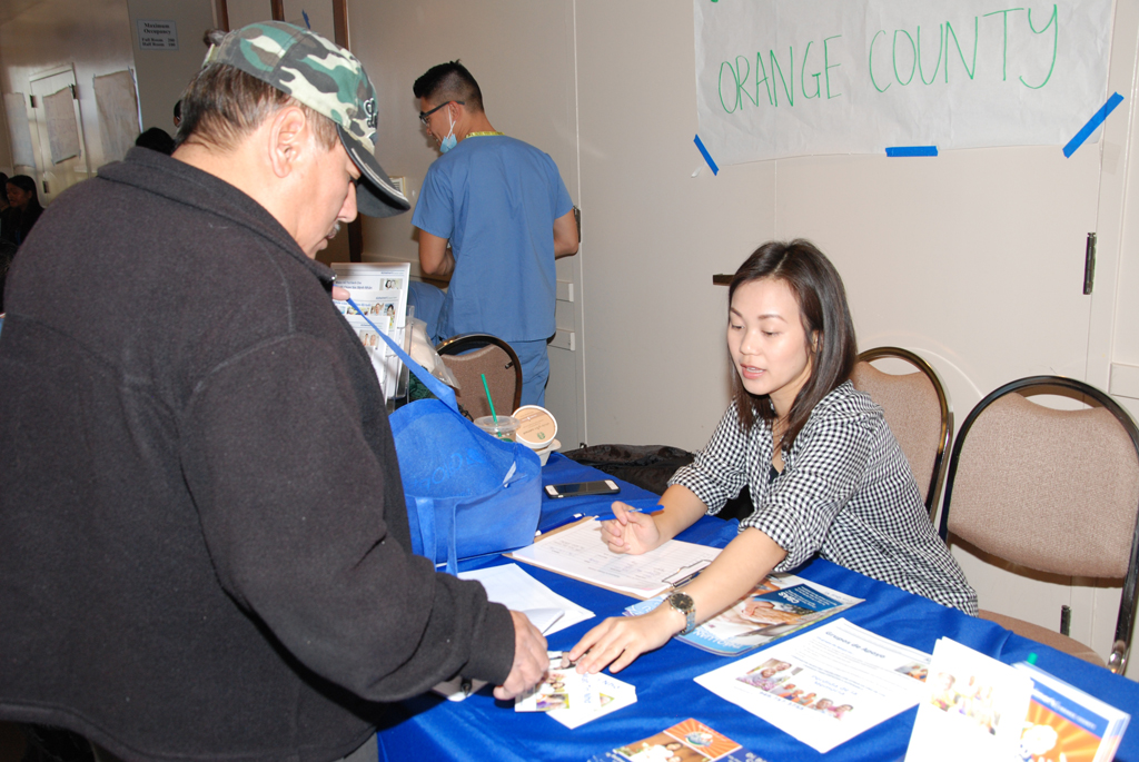Cô Minh Thư của hội Alzheimer's Orange County niềm nở cung cấp tài liệu cho đồng hương. (Hình: Nguyên Huy/Người Việt)
