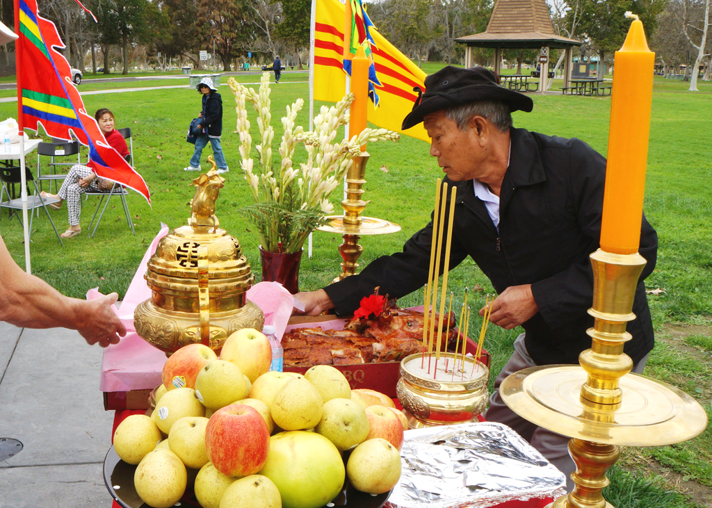 Ông Phan Văn Chính sắp đặt bàn thờ hương án. (Hình: Lâm Hoài Thạch/Người Việt)