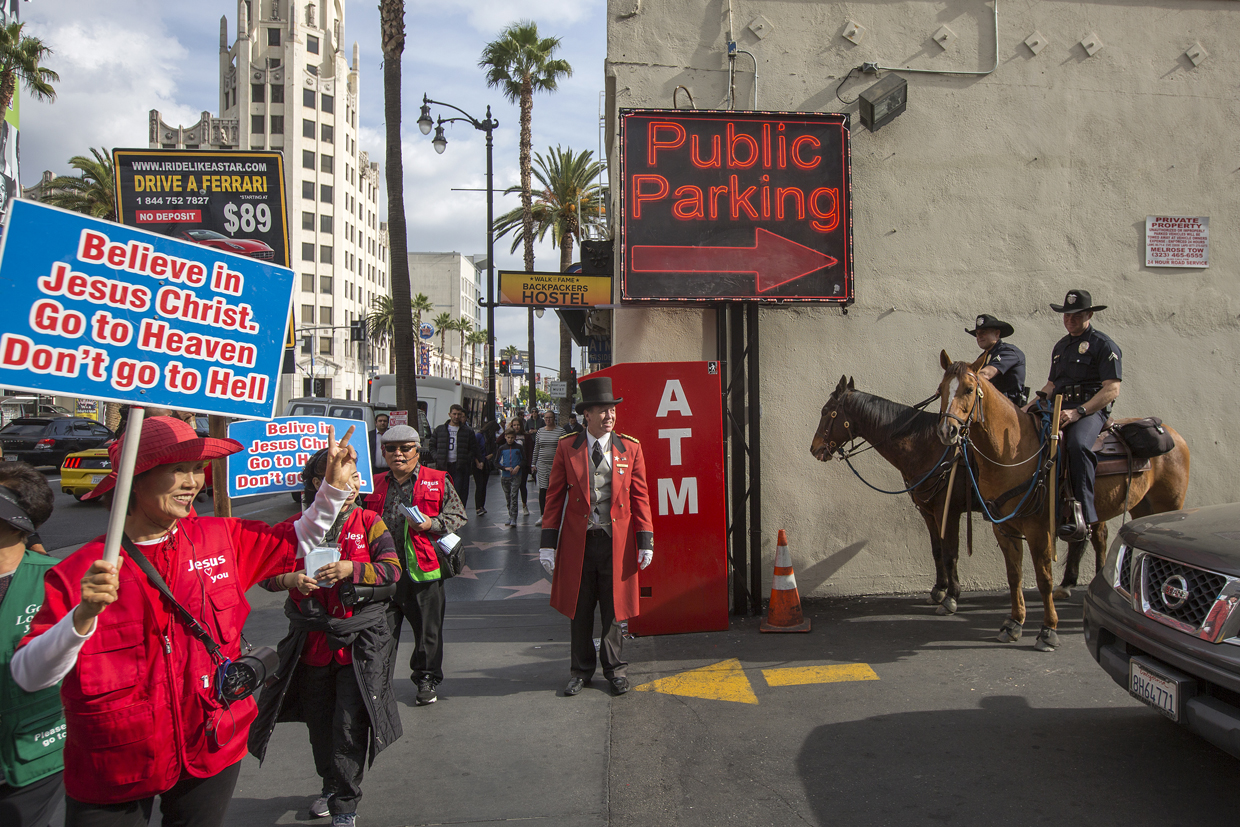 LOS ANGELES, CA - DECEMBER 06: A group of evangelizing Christians marches past Los Angeles Police Department Mounted Platoon officers on Hollywood Boulevard as police and deputies step up security near the Hollywood/Highland Red Line Metro train station and other stops on December 6, 2016 in Los Angeles, California. An increase in security is in response to Federal and Los Angeles officials who say they were alerted by authorities in another country that an imminent and very specific threat has been made against the city's Red Line commuter rail system. (Photo by David McNew/Getty Images)