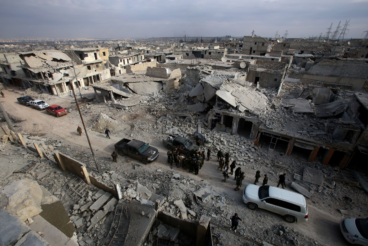 Syrian pro-government forces patrol Aleppo's Sheikh Saeed district, on December 12, 2016, after retaking the area from rebel fighters. / AFP / Youssef KARWASHAN (Photo credit should read YOUSSEF KARWASHAN/AFP/Getty Images)