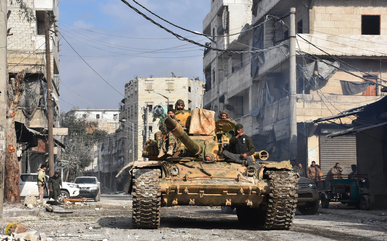 Syrian pro-government forces patrol Aleppo's eastern al-Salihin neighbourhood on December 12, 2016 after troops retook the area from rebel fighters. / AFP / GEORGE OURFALIAN (Photo credit should read GEORGE OURFALIAN/AFP/Getty Images)