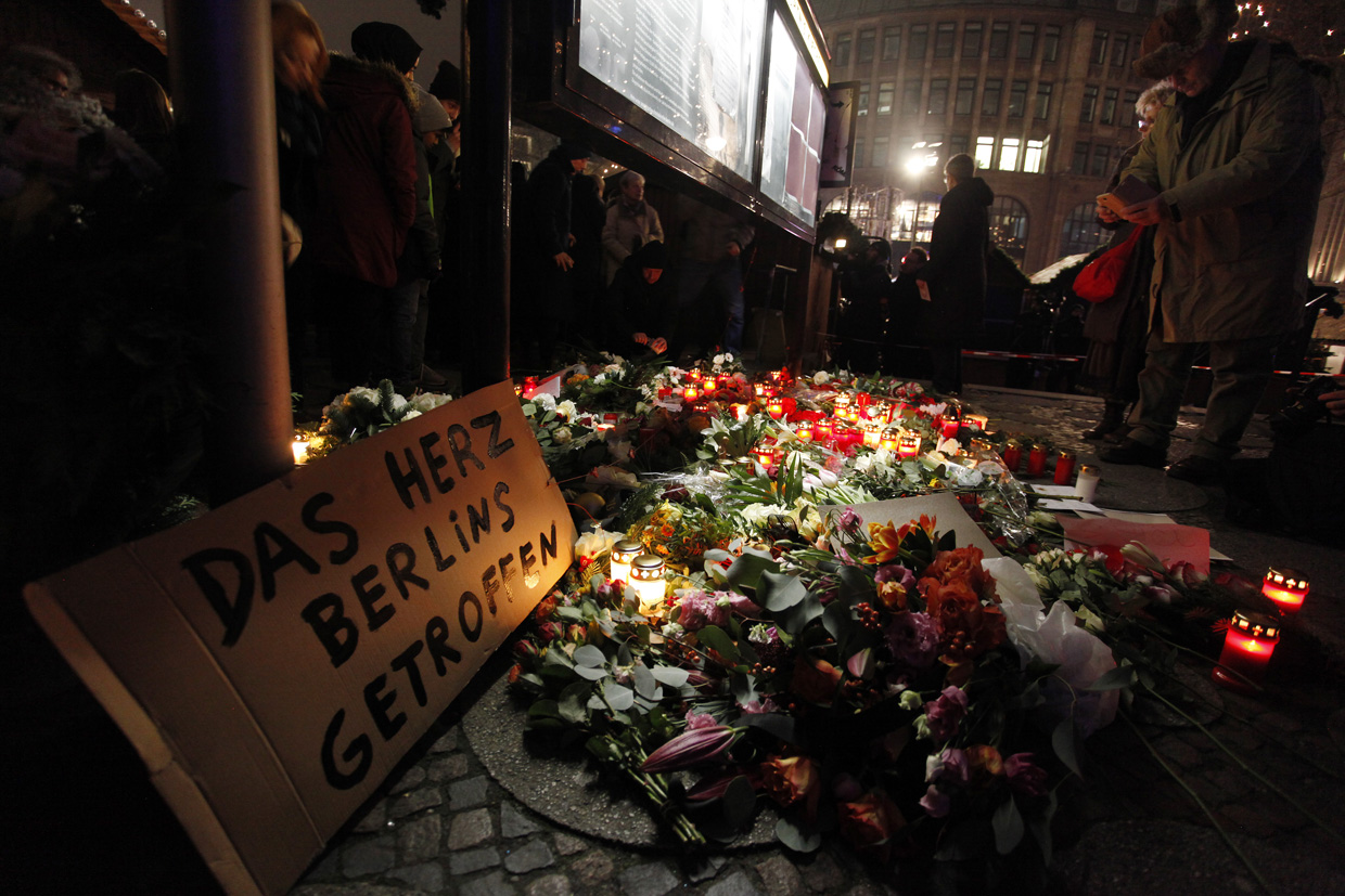 BERLIN, GERMANY - DECEMBER 20: A sign reads 'the heart of Berlin has been hit', as people leave flowers and candles at the area after a lorry truck ploughed through a Christmas market on December 20, 2016 in Berlin, Germany. So far 12 people are confirmed dead and 45 injured. Authorities have confirmed they believe the incident was an attack and have arrested a Pakistani man who they believe was the driver of the truck and who had fled immediately after the attack. Among the dead are a Polish man who was found on the passenger seat of the truck. Police are investigating the possibility that the truck, which belongs to a Polish trucking company, was stolen yesterday morning. (Photo by Michele Tantussi/Getty Images)