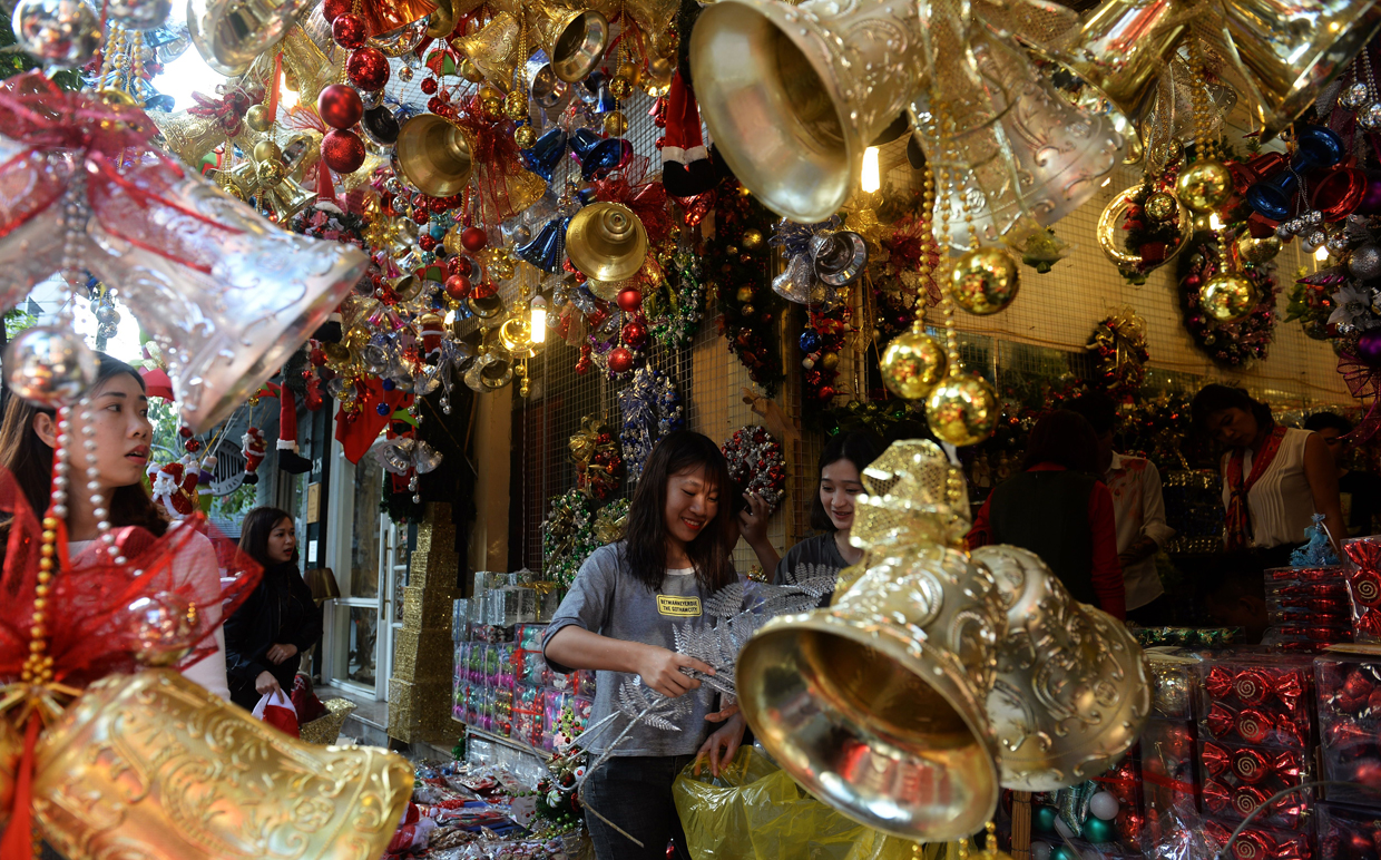 This photo taken on December 21, 2016 shows women shopping at a store selling Christmas items in downtown Hanoi. / AFP / HOANG DINH NAM (Photo credit should read HOANG DINH NAM/AFP/Getty Images)