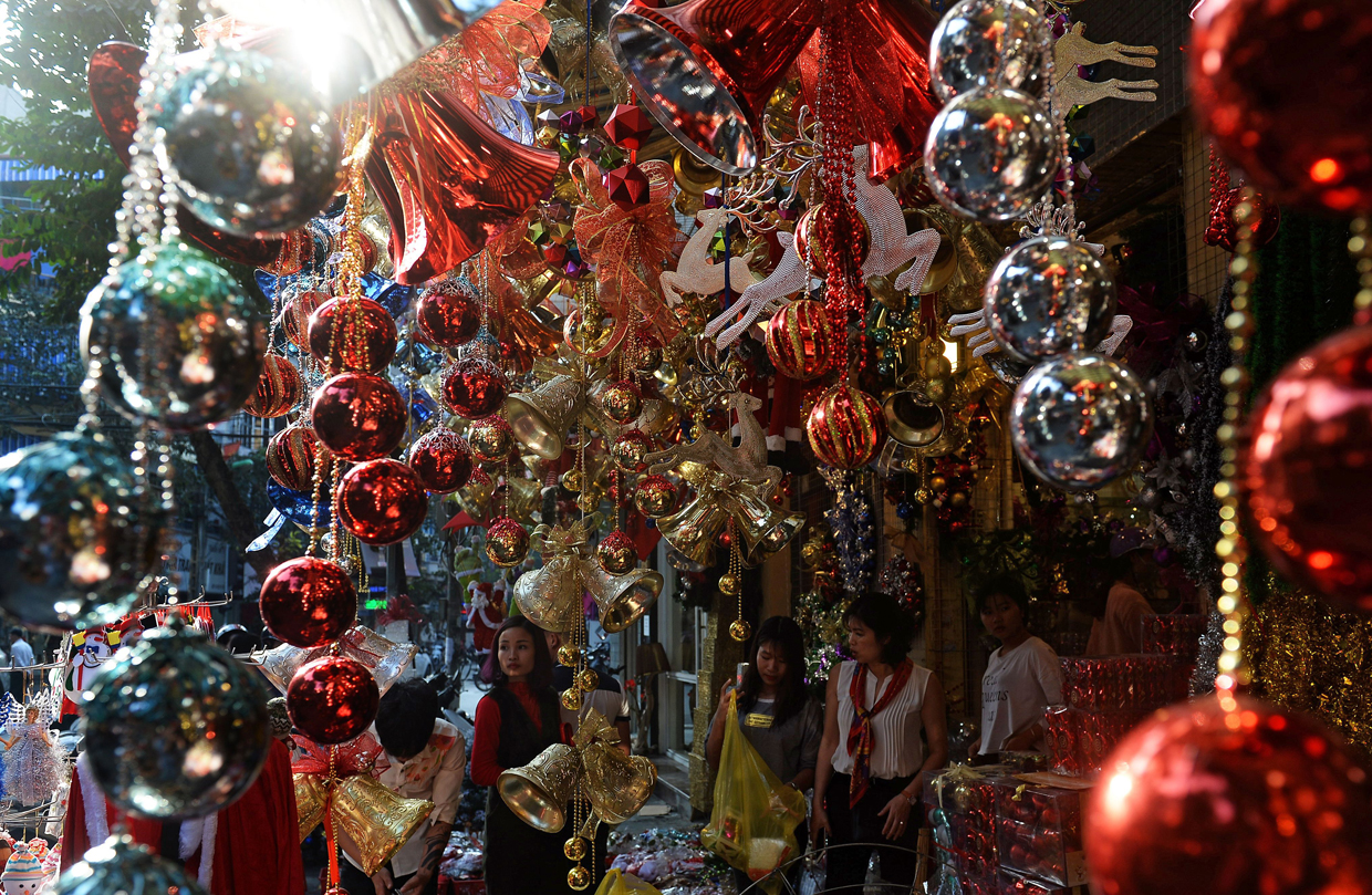 This photo taken on December 21, 2016 shows shows women shopping at a store selling Christmas items in downtown Hanoi. / AFP / HOANG DINH NAM (Photo credit should read HOANG DINH NAM/AFP/Getty Images)