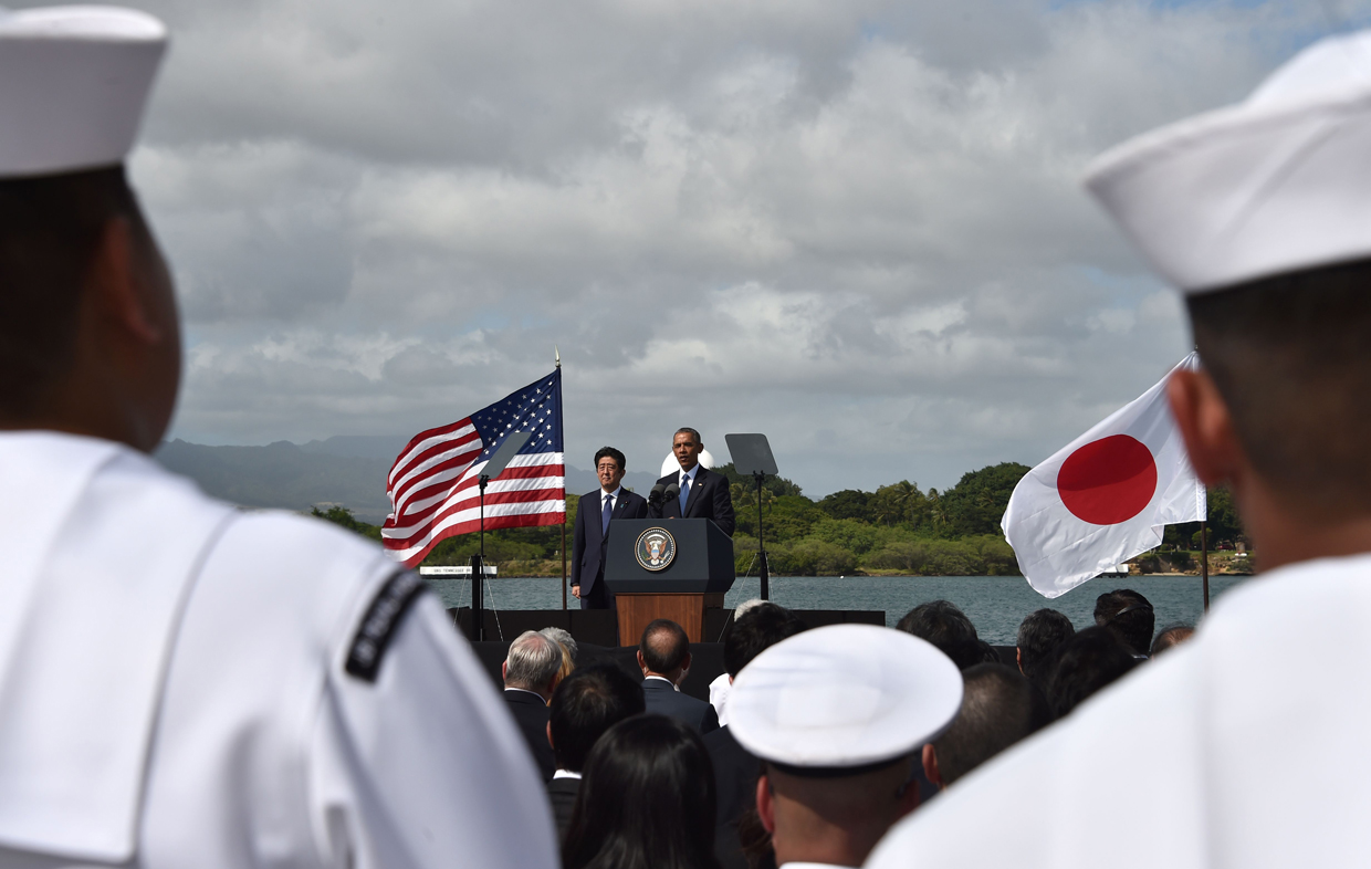 US President Barack Obama (C) speaks as Japanese Prime Minister Shinzo Abe listens at Kilo Pier overlooking the USS Arizona Memorial on December 27, 2016 at Pearl Harbor in Honolulu, Hawaii. Abe and Obama made a joint pilgrimage to the site of the Pearl Harbor attack on Tuesday to celebrate "the power of reconciliation. "The Japanese attack on an unsuspecting US fleet moored at Pearl Harbor turned the Pacific into a cauldron of conflict -- more than 2,400 were killed and a reluctant America was drawn into World War II. / AFP / Nicholas Kamm (Photo credit should read NICHOLAS KAMM/AFP/Getty Images)