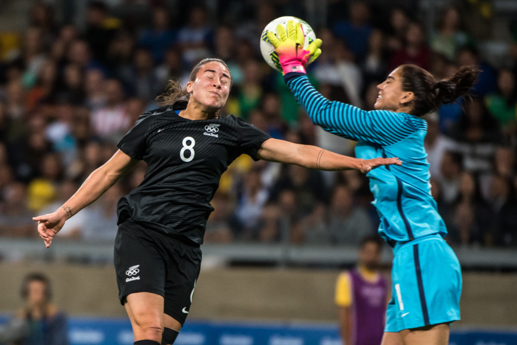 Thủ môn đội tuyển nữ Hoa Kỳ Hope Solo (phải) nhảy lên bắt dính banh trước đối thủ Jasmine Pereira của đội tuyển nữ New Zealand trong trận đấu bảng G bóng tròn nữ Thế Vận Hội Rio 2016 giữa tuyển nữ Hoa Kỳ và New Zealand diễn ra tại Mineirao stadium, Belo Horizonte, Brazil ngày 3 Tháng Tám, 2016. (Hình: Getty Images)