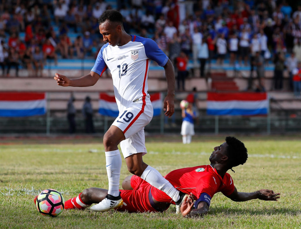 Cầu thủ Cuba Daniel Ernesto Luis Saez số 6 té ngã trong khi tranh chấp bóng với tiền đạo số 19 Julian Green của đội tuyển Hoa Kỳ trong trận đấu giao hữu giữa hai đội tuyển Mỹ và Cuba diễn ra tại Estadio Pedro Marrero, Havana, Cuba ngày 7 Tháng Mười, 2016. (Hình: Getty Images)