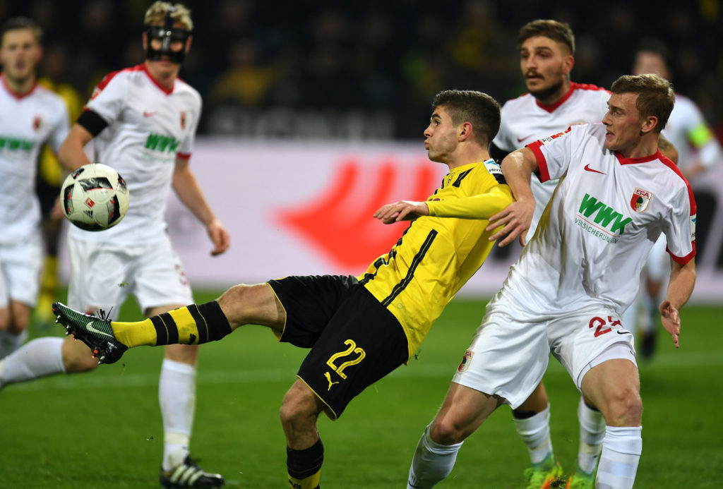 Tiền vệ Hoa Kỳ, Pulisic của đội Dortmund trong vòng vây truy cản của các cầu thủ đội Augsburg trong trận đấu giải Bundesliga giữa Borussia Dortmund và Augsburg diễn ra tại Dortmund, Đức ngày 20 Tháng Mười Hai, 2016. (Hình: Getty Images)