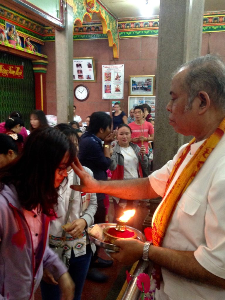 Có thể khác biệt tôn giáo, nhưng điểm chấm đỏ trên trán theo nghi lễ của đạo Hindu vẫn luôn là điều may mắn trong năm mới. (Hình: Trần Tiến Dũng/Người Việt)