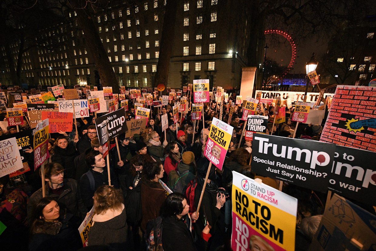 LONDON, ENGLAND - JANUARY 30: Demonstrators hold placards as they protest outside Downing Street on January 30, 2017 in London, England. President Trump signed an executive order on Friday banning immigration to the USA from seven muslim countries. This led to protests across America and, today, the UK. A British petition asking for the downgrading of Trump's State visit passed one million signatures this morning. (Photo by Leon Neal/Getty Images)
