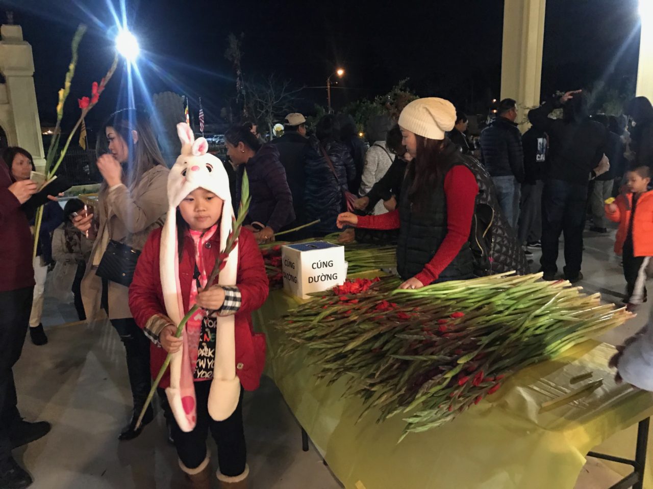 Một em nhỏ lấy lộc đầu năm tại chùa Điều Ngự, Westminster.