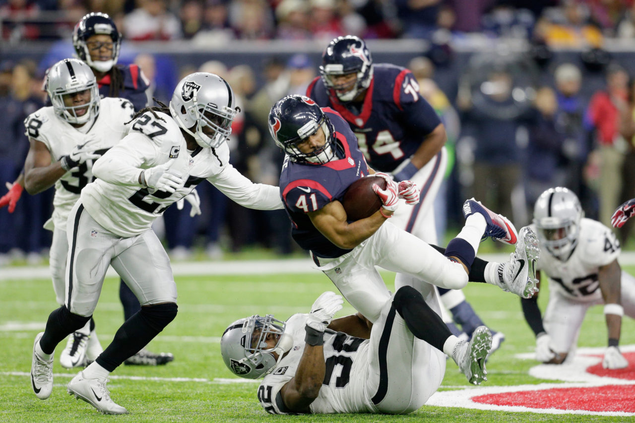 Jonathan Grimes số 41 của Houston Texans ôm banh bị Khalil Mack số 52 của Oakland Raiders truy cản trong trận đấu AFC Wild Card giữa hai đội diễn ra tại NRG Stadium, Houston, Texas ngày 7 Tháng Giêng, 2017. (Hình: Getty Images)