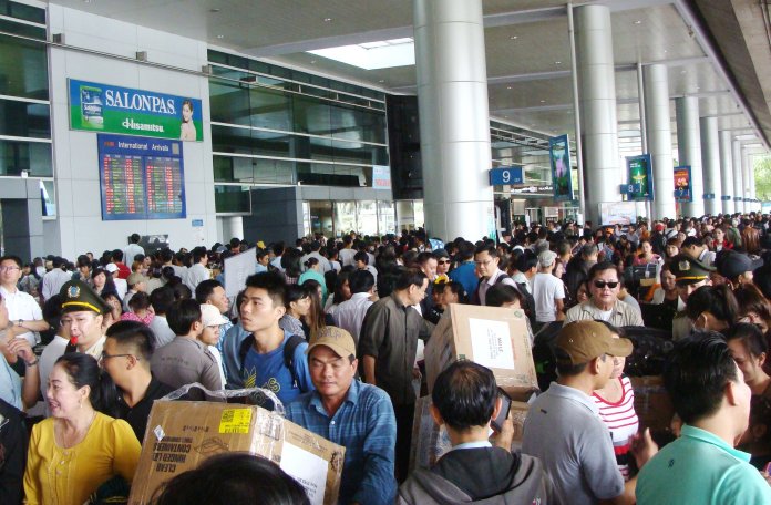 Phi trường Tân Sơn Nhất bị quá tải do chật kín người. (Hình: Bình Lâm/Người Việt)
