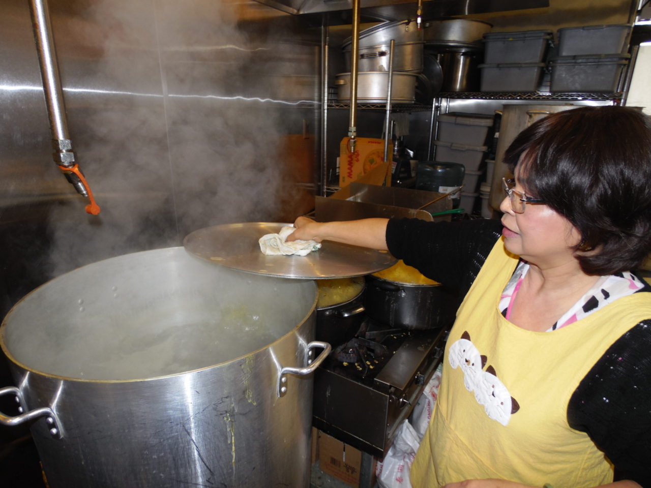 Bà Tâm bên nồi bánh chưng nấu chín. (Hình: Linh Nguyễn/Người Việt)