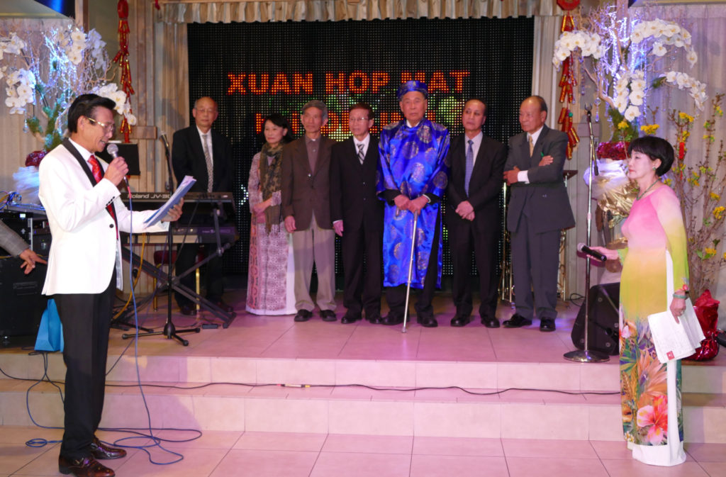Anh Phí Văn Nghĩa (trái) chúc Tết thầy cô. (Hình: Văn Lan/Người Việt)