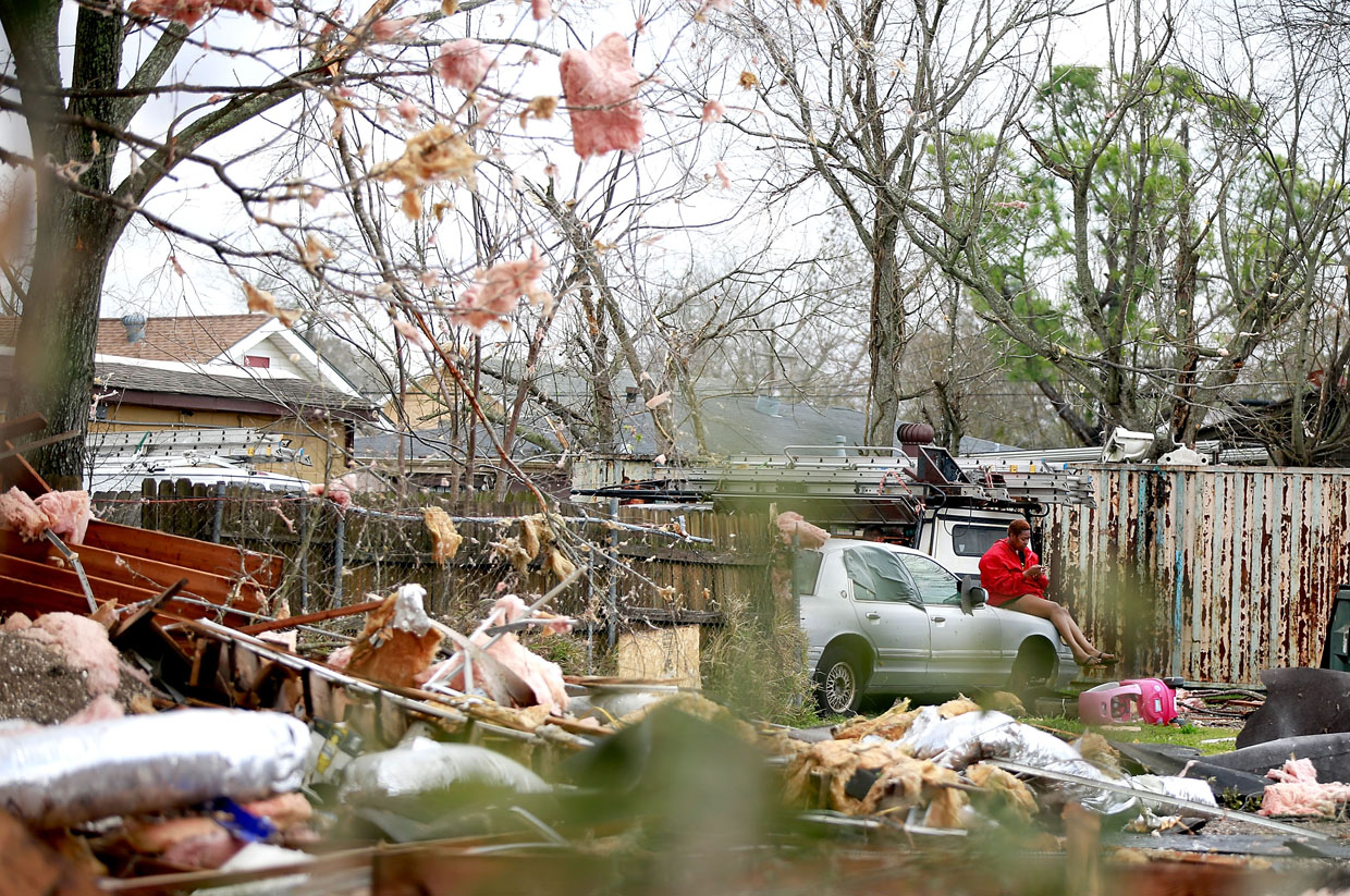 NEW ORLEANS, LA - FEBRUARY 07: A woman sits on a car surrounded by debris along Chef Menture Ave after a tornado touched down in the eastern part of the city on February 7, 2017 in New Orleans, Louisiana. According to the weather service, 25 people were injured in the aftermath of the tornado. (Photo by Sean Gardner/Getty Images)