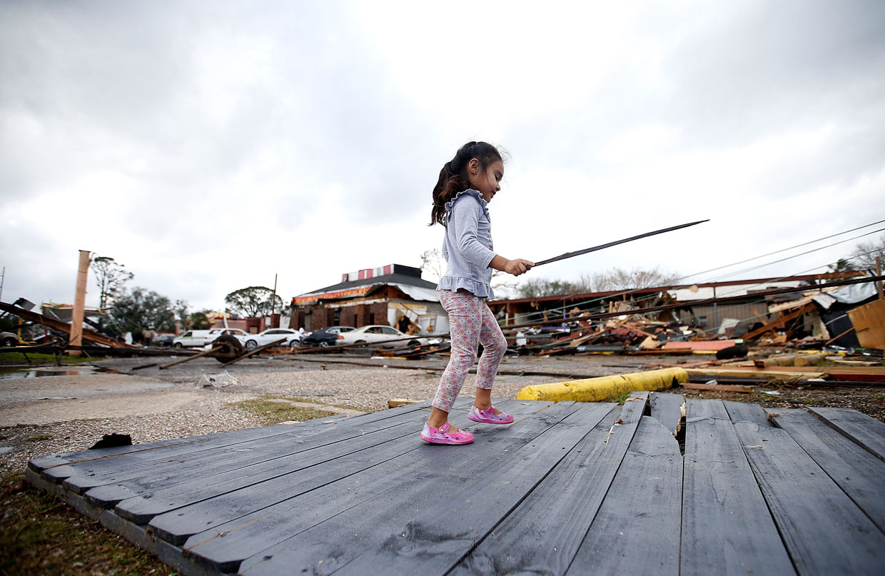 NEW ORLEANS, LA - FEBRUARY 07: A little girl plays with a broken stick amongst the debris that was left behind by a tornad on on February 7, 2017 in New Orleans, Louisiana. According to the weather service 25 people were injured in the aftermath of the tornado. (Photo by Sean Gardner/Getty Images)