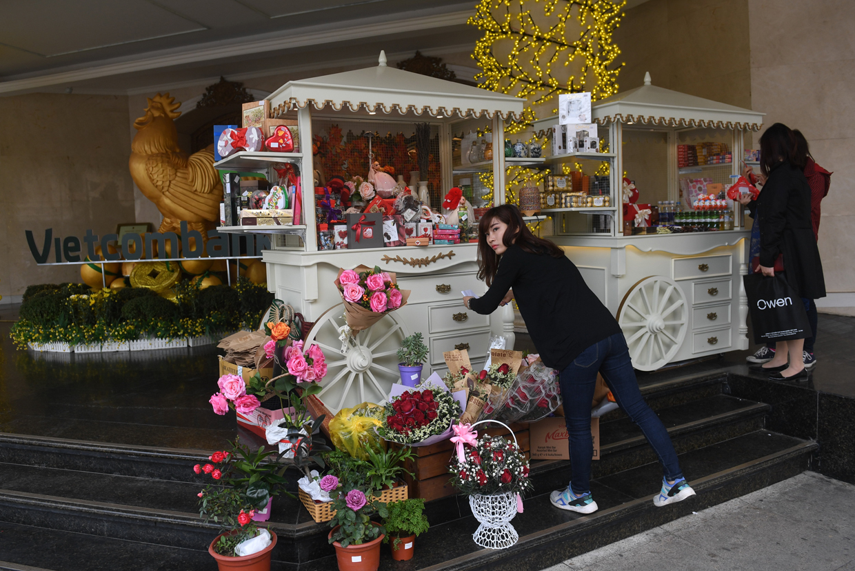 A vendor arranges her stall of chocolates and flowers for Valentine's Day in Hanoi on February 14, 2017. / AFP / HOANG DINH NAM (Photo credit should read HOANG DINH NAM/AFP/Getty Images)