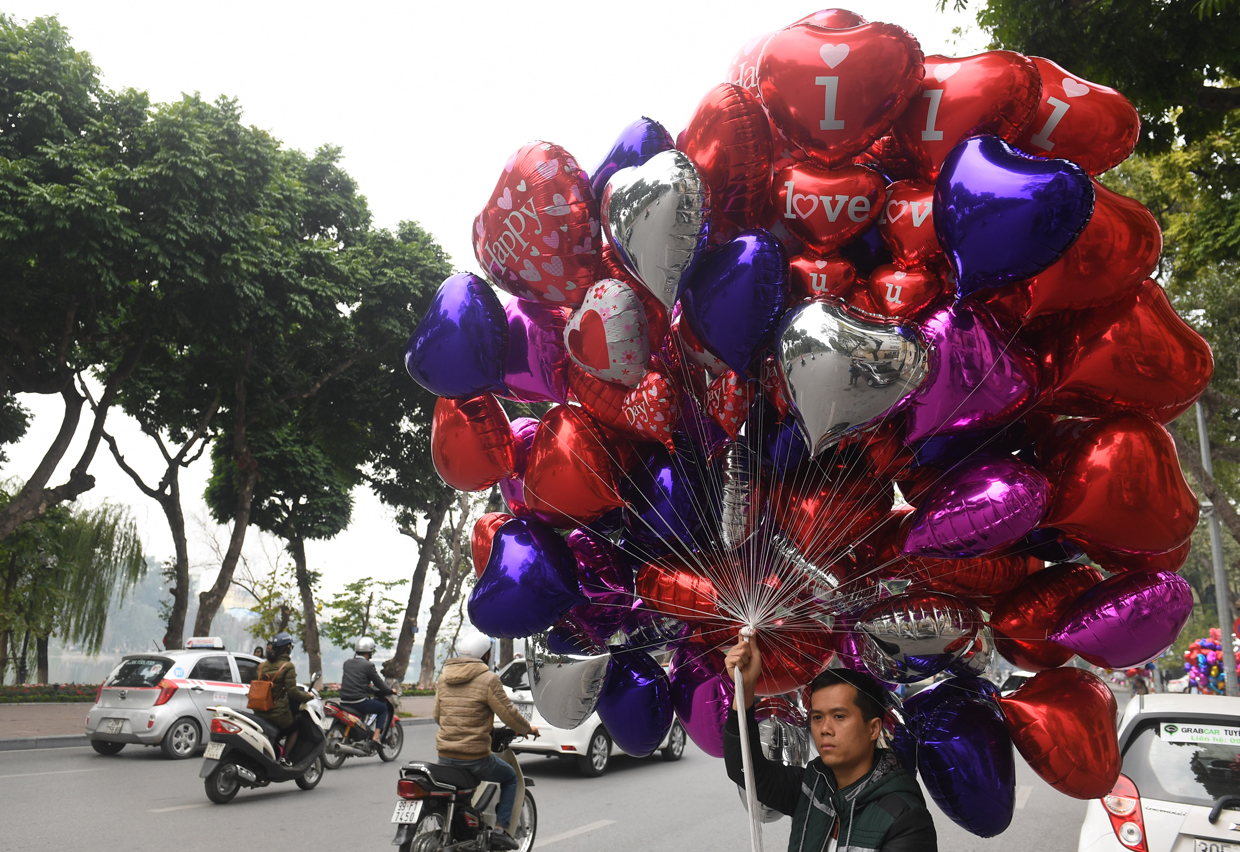 A vendor sells heart-shaped balloons on Valentine's Day in Hanoi on February 14, 2017. / AFP / HOANG DINH NAM (Photo credit should read HOANG DINH NAM/AFP/Getty Images)