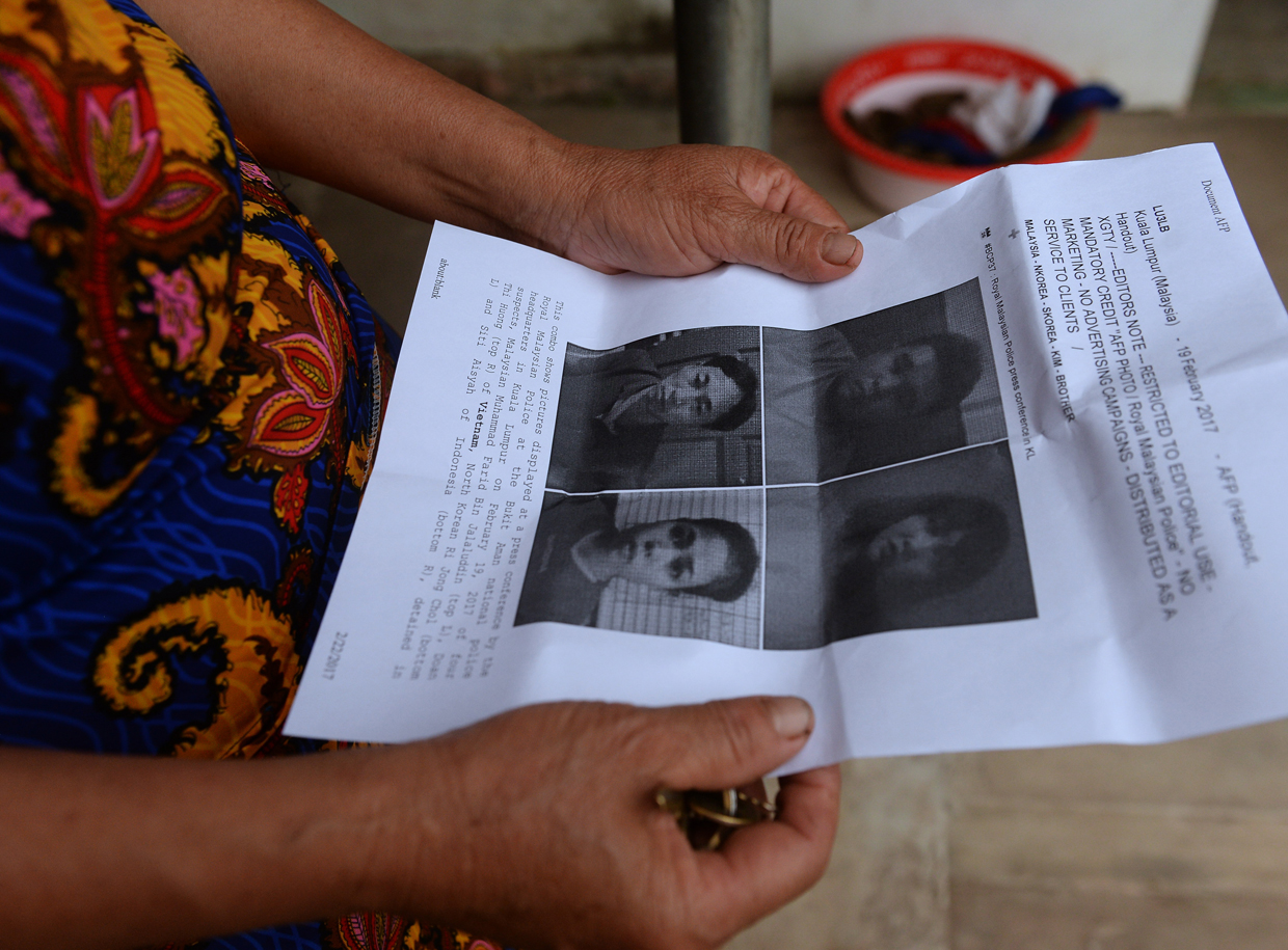 CORRECTION - Nguyen Thi Vy, 54, stepmother of Doan Thi Huong, a suspect involved in the assassination of Kim Jong-Un's half-brother, looks at handouts and published photographs of the four arrested suspects including Huong at Huong's family home in Nghia Hung district, northern province of Nam Dinh on February 22, 2017. Detectives probing the assassination of Kim Jong-Un's half-brother want to question a North Korean diplomat, Malaysia's top policeman said. Royal Malaysian Police chief Khalid Abu Bakar said Vietnamese suspect Doan Thi Huong, 28, and Indonesian Siti Aishah, 25, had been trained to swab the man's face, practising in Kuala Lumpur before the assault at the airport. / AFP / HOANG DINH NAM / The erroneous mention[s] appearing in the metadata of this photo by HOANG DINH NAM has been modified in AFP systems in the following manner: [stepmother ] instead of [mother in law]. Please immediately remove the erroneous mention[s] from all your online services and delete it (them) from your servers. If you have been authorized by AFP to distribute it (them) to third parties, please ensure that the same actions are carried out by them. Failure to promptly comply with these instructions will entail liability on your part for any continued or post notification usage. Therefore we thank you very much for all your attention and prompt action. We are sorry for the inconvenience this notification may cause and remain at your disposal for any further information you may require. / (Photo credit should read HOANG DINH NAM/AFP/Getty Images)