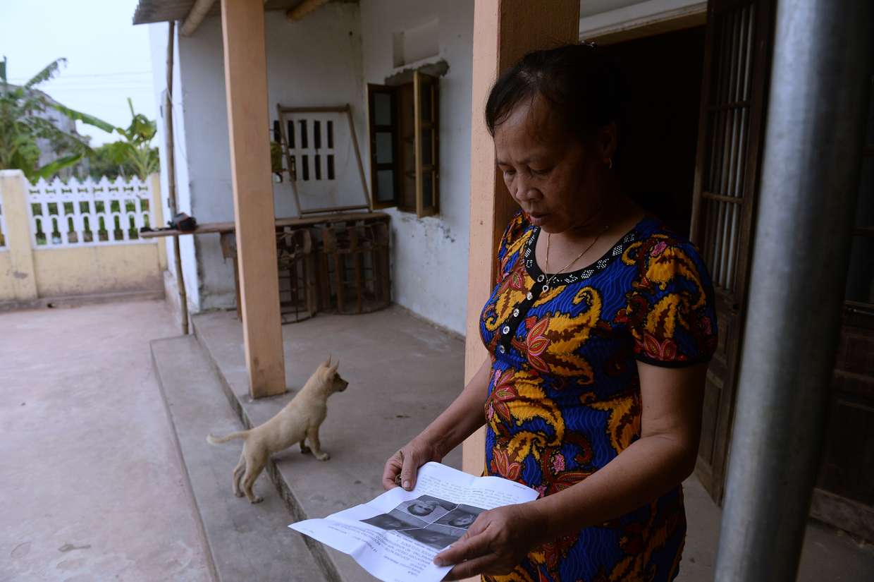 CORRECTION - Nguyen Thi Vy, 54, stepmother of Doan Thi Huong, a suspect involved in the assassination of Kim Jong-Un's half-brother, looks at handouts and published photographs of the four arrested suspects including Huong at Huong's family home in Nghia Hung district, northern province of Nam Dinh on February 22, 2017. Detectives probing the assassination of Kim Jong-Un's half-brother want to question a North Korean diplomat, Malaysia's top policeman said. Royal Malaysian Police chief Khalid Abu Bakar said Vietnamese suspect Doan Thi Huong, 28, and Indonesian Siti Aishah, 25, had been trained to swab the man's face, practising in Kuala Lumpur before the assault at the airport. / AFP / HOANG DINH NAM / The erroneous mention[s] appearing in the metadata of this photo by HOANG DINH NAM has been modified in AFP systems in the following manner: [stepmother ] instead of [mother in law]. Please immediately remove the erroneous mention[s] from all your online services and delete it (them) from your servers. If you have been authorized by AFP to distribute it (them) to third parties, please ensure that the same actions are carried out by them. Failure to promptly comply with these instructions will entail liability on your part for any continued or post notification usage. Therefore we thank you very much for all your attention and prompt action. We are sorry for the inconvenience this notification may cause and remain at your disposal for any further information you may require. / (Photo credit should read HOANG DINH NAM/AFP/Getty Images)