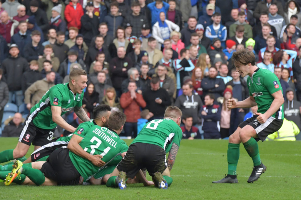 Hậu vệ Sean Raggett của Lincoln City, cùng các đồng đội ôm nhau vui mừng sau khi ghi bàn thắng vào lưới đội Burnley trong trận đấu vòng thứ 5 FA Cup giữa hai đội Lincoln City và Burnley diễn ra trên sân Turf Moor, Burnley, ngày 18 Tháng Hai, 2017. (Hình: Getty Images)