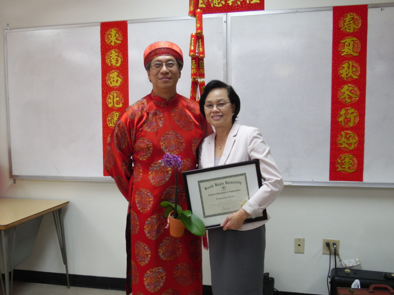 Giáo Sư Ðinh Tiến Linh (phải), nhận bằng tưởng lục, bên cạnh là ông Peter Nguyễn, đại diện sinh viên, MC buổi tiệc liên hoan.