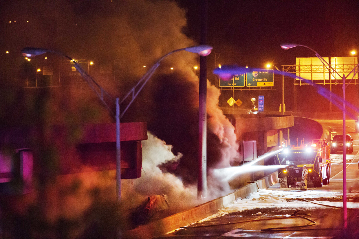 Smoke billows from a section of an overpass that collapsed from a large fire on Interstate 85 in Atlanta, Thursday, March 30, 2017. Witnesses say troopers were telling cars to turn around on the bridge because they were concerned about its integrity. Minutes later, the bridge collapsed. (AP Photo/David Goldman)