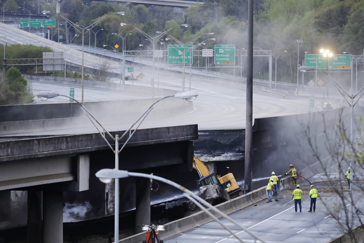 Crews work on a section of an overpass that collapsed from a large fire on Interstate 85 in Atlanta, Friday, March 31, 2017. Many commuters in some of Atlanta's densely populated northern suburbs will have to find alternate routes or ride public transit for the foreseeable future after a massive fire caused a bridge on Interstate 85 to collapse Thursday, completely shutting down the heavily traveled highway. (AP Photo/David Goldman)