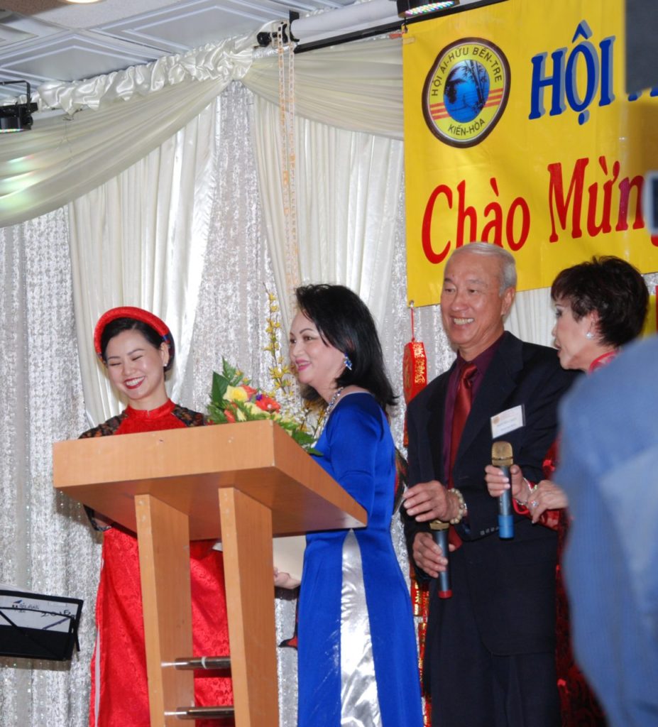 Từ trái, cô Hạnh Vy, đại diện tuổi trẻ Bến Tre, chúc mừng đồng hương; Hội Trưởng Đoàn Huyền Trang; trưởng ban tổ chức Phạm Yên Đằng; và nữ MC trong buổi hội ngộ Bến Tre. (Hình: Nguyên Huy/Người Việt)