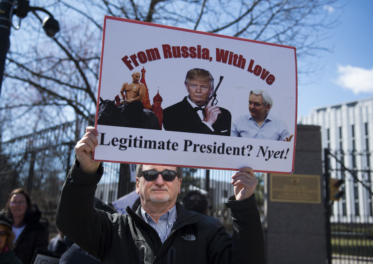 An anti-Trump protester holds a sign outside the Embassy of Russia on March 4, 2017, in Washington, DC. / AFP PHOTO / MOLLY RILEY (Photo credit should read MOLLY RILEY/AFP/Getty Images)