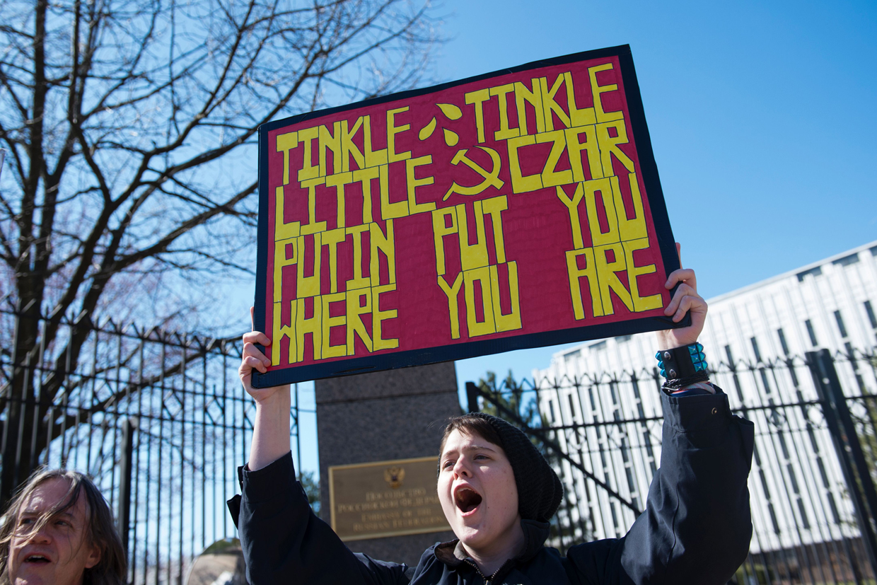An anti-Trump protester holds a sign outside the Embassy of Russia on March 4, 2017, in Washington, DC. / AFP PHOTO / MOLLY RILEY (Photo credit should read MOLLY RILEY/AFP/Getty Images)