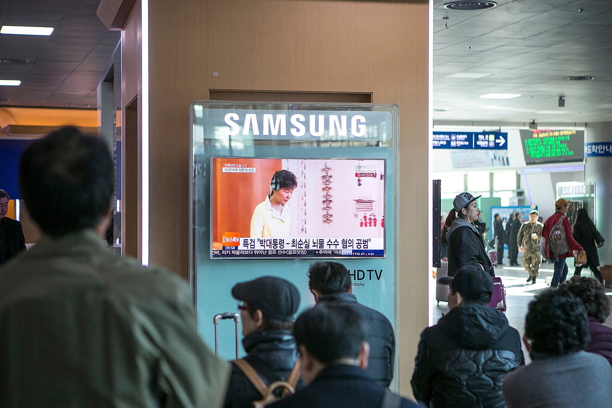 SEOUL, SOUTH KOREA - MARCH 10: Travelers watch the news reporting on South Korean President Park Geun-hye's impeachment ruling while they wait for their trains at the Seoul Station on March 10, 2017 in Seoul, South Korea. The verdict on South Korean President Park's impeachment will be delivered by the Constitutional Court at 11 a.m on March 10, 2017. The hearing will be televised live from the main courtroom; Park is not expected to attend the hearing. (Photo by Jean Chung/Getty Images)