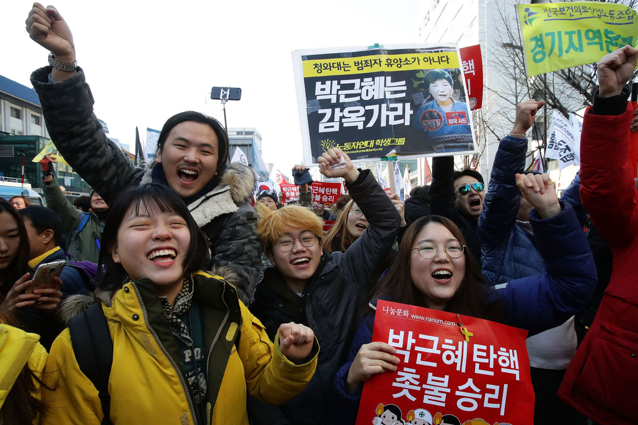 SEOUL, SOUTH KOREA - MARCH 10: South Koreans celebrate after hearing the Constitutional Court's verdict on March 10, 2017 in Seoul, South Korea. South Korean President Park Geun-hye will be permanently removed from the South Korean office and the nation will need to hold a presidential election within 60 days. Park had been impeached by parliament in December for allegedly letting her confidante Choi Soon-sil involved in state affairs and colluded to take bribes of millions of dollars from South Korean conglomerates. (Photo by Chung Sung-Jun/Getty Images)