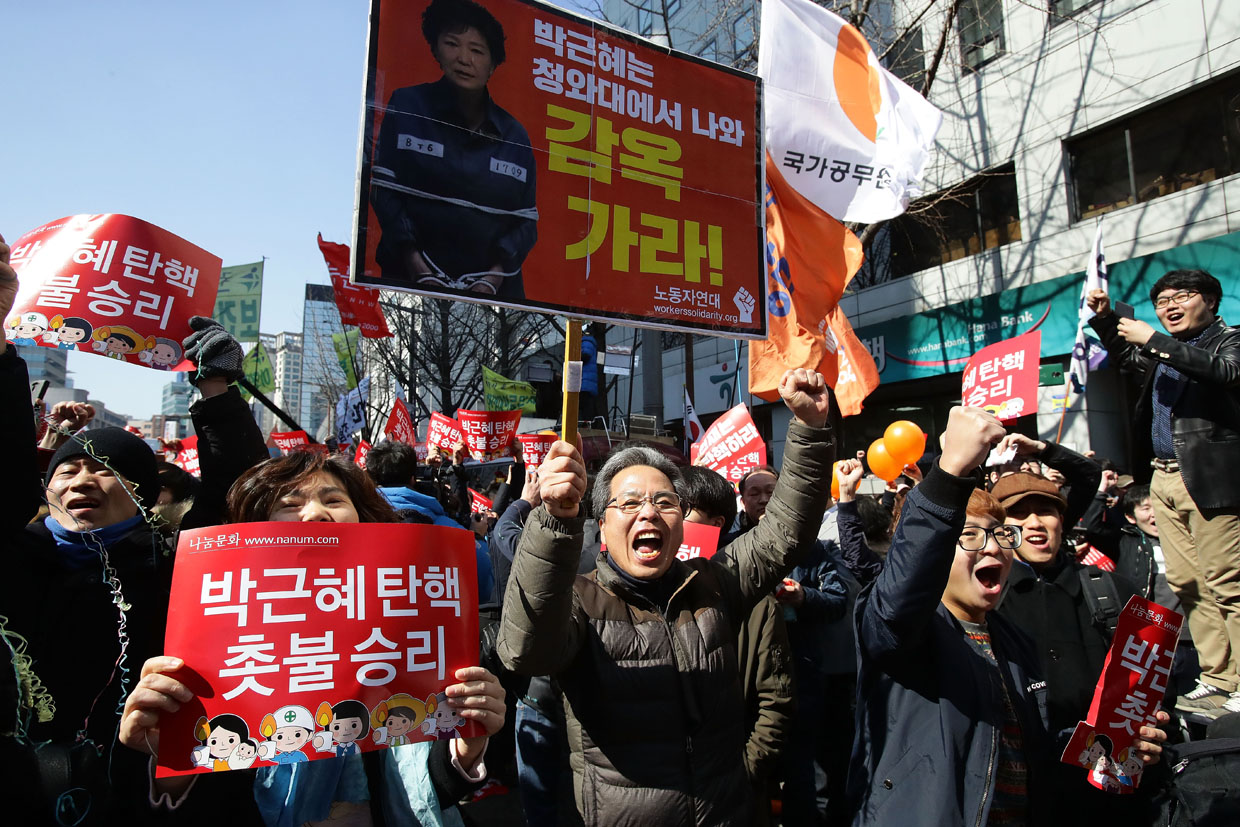 SEOUL, SOUTH KOREA - MARCH 10: South Koreans celebrate after hearing the Constitutional Court's verdict on March 10, 2017 in Seoul, South Korea. South Korean President Park Geun-hye will be permanently removed from the South Korean office and the nation will need to hold a presidential election within 60 days. Park had been impeached by parliament in December for allegedly letting her confidante Choi Soon-sil involved in state affairs and colluded to take bribes of millions of dollars from South Korean conglomerates. (Photo by Chung Sung-Jun/Getty Images)