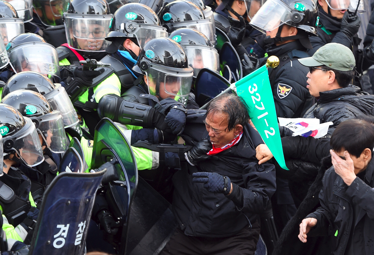 TOPSHOT - South Korean supporters of Park Geun-Hye clash with police after the announcement of the Constitutional Court over the impeachment of South Korea's President Park Geun-Hye in Seoul on March 10, 2017. The rival crowds outside South Korea's constitutional court on March 10 for the verdict on impeached president Park Geun-Hye epitomised the opposing passions and generational splits over the country's sweeping political scandal. / AFP PHOTO / JUNG Yeon-Je (Photo credit should read JUNG YEON-JE/AFP/Getty Images)