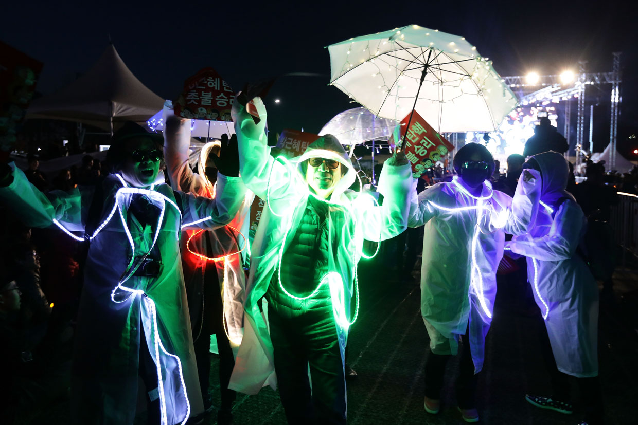 SEOUL, SOUTH KOREA - MARCH 10: South Koreans celebrate after the Constitutional Court's verdict on March 10, 2017 in Seoul, South Korea. The Constitutional Court of South Korea upheld the impeachment of President Park Geun-hye on March 10, 2017. Park will be permanently removed from the South Korean office and the nation will need to hold a presidential election within 60 days. Park had been impeached by parliament in December for allegedly letting her confidante Choi Soon-sil involved in state affairs and colluded to take bribes of millions of dollars from South Korean conglomerates. (Photo by Chung Sung-Jun/Getty Images)