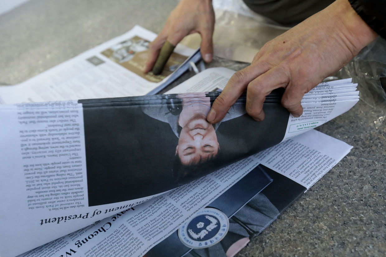 SEOUL, SOUTH KOREA - MARCH 10: A South Korean man hold up a extra edition newspaper reporting impeached President Park Geun-hye on March 10, 2017 in Seoul, South Korea. The Constitutional Court of South Korea upheld the impeachment of President Park Geun-hye on March 10, 2017. Park will be permanently removed from the South Korean office and the nation will need to hold a presidential election within 60 days. Park had been impeached by parliament in December for allegedly letting her confidante Choi Soon-sil involved in state affairs and colluded to take bribes of millions of dollars from South Korean conglomerates. (Photo by Chung Sung-Jun/Getty Images)